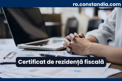 Certificat de rezidență fiscală – documente și laptop pe birou pentru verificare fiscală.